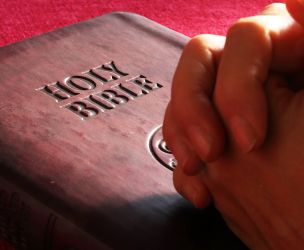 Person Hands on Holy Bible